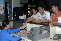 Nhân viên Ga Sài Gòn bán vé phục vụ hành khách. (Ảnh: Hoàng Hải/TTXVN). 