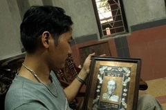 Nghệ nhân trẻ Nguyễn Đình Vinh bên 1 tác phẩm chân dung Bác. (Nguồn: Internet)