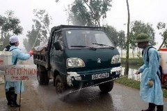 Phun thuốc tiêu độc tại một chốt kiểm dịch. (Ảnh: Hoàng Hùng/TTXVN)