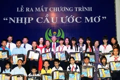 Tặng quà cho các em học sinh nghèo học giỏi tiêu biểu năm học 2012-2013. (Ảnh: Hoàng Hải/Vietnam+) 