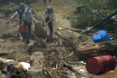 Học sinh ở Bản Khoang tìm lại đồ dùng học tập sau khi bị lũ quét hồi đầu tháng 9. (Ảnh: Lục Văn Toán/TTXVN)