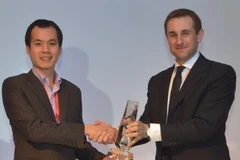 Ông Trịnh Hoài Nam, Phó Giám đốc Công ty Kiều hối Đông Á nhận giải thưởng từ đại diện của MoneyGram. (Ảnh: Hà Huy Hiệp/Vietnam+)