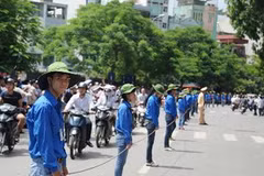 Sinh viên tình nguyện làm rào chắn đảm bảo giao thông cho thí sinh ra về tại trường Đại học Bách Khoa Hà Nội. (Ảnh: Vũ Văn Long/TTXVN)
