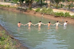 Thanh niên dàn hàng ngang dò tìm nạn nhân. (Ảnh: VnExpress)