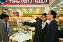 Đại diện hai bên tham quan siêu thị thegioididong.com sau buổi lễ ký kết. (Ảnh: Mỹ Phương/Vietnam+) 