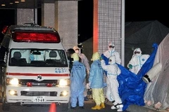 Các nhân viên bị phơi nhiễm được lực lượng chức năng chuyển đến bệnh viên. (Ảnh: Cao Phong/Vietnam+)