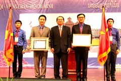 Ông Soucan Mahalath, Bí thư Trung ương Đảng Nhân dân Cách mạng Lào, Bí thư Thành ủy kiêm Đô trưởng Vientiane trao Huân chương cho đại diện thành niên Hà Nội và TP.HCM. (Ảnh: Hoàng Chương/Vietnam+)