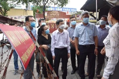 Thứ trưởng Bộ Y tế Nguyễn Trường Sơn thăm hỏi cán bộ địa phương trong công tác chống dịch. (Ảnh: Đinh Hằng/TTXVN)