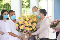 Một bệnh nhân được công bố khỏi bệnh tặng hoa cho các y bác sỹ. (Ảnh minh họa: Vietnam+)