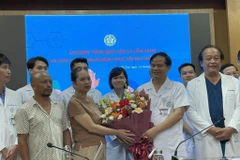 Gia đình Hà Thị B. tặng hoa cảm ơn các y bác sỹ Bệnh viện Bạch Mai. (Ảnh: PV/Vietnam+)