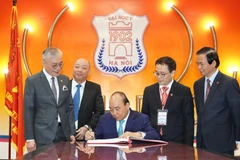 Thủ tướng Nguyễn Xuân Phúc đến dự Lễ kỷ niệm 65 năm Ngày Thầy thuốc Việt Nam tại Trường Đại học Y Hà Nội và viết vào sổ lưu niệm. (Ảnh: PV/Vietnam+)