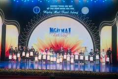 Các vị lãnh đạo tặng quà cho các bệnh nhân ung thư trong Chương trình. (Ảnh: PV/Vietnam+)