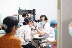 Bác sỹ khám mắt cho bệnh nhân. (Ảnh: PV/Vietnam+)