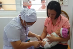 Nhân viên y tế tiêm chủng cho trẻ nhỏ. (Ảnh: T.G/Vietnam+)