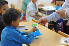 Nhân viên y tế cấp phát thuốc uống phòng dịch bạch hầu cho học sinh. (Ảnh: Hoàng Hiếu/TTXVN)