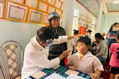 Bác sĩ khám cho trẻ trong Chương trình tại tỉnh Đắk Lắk. (Ảnh: PV/Vietnam+)