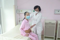 Bác sỹ Nguyễn Thanh Hà thăm khám cho bệnh nhân sau phẫu thuật. (Ảnh: PV/Vietnam+)