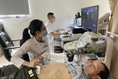 Nhân viên y tế thực hiện siêu âm ổ bụng cho một bệnh nhân. (Ảnh: PV/Vietnam+)