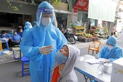 Lấy mẫu xét nghiệm cho người dân. (Ảnh: TTXVN/Vietnam+)