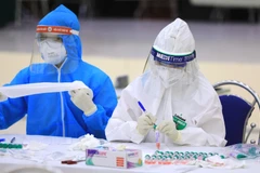 Lấy mẫu xét nghiệm cho các bệnh nhân. (Ảnh: TTXVN/Vietnam+)