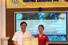 Phó giáo sư Đào Xuân Cơ trao giấy khen cho nữ điều dưỡng Đặng Thị Hạ. (Ảnh: PV/Vietnam+)