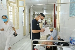 Bác sỹ theo dõi tình hình sức khỏe cho một bệnh nhân mắc sốt xuất huyết tại Hà Nội. (Ảnh: Minh Quyết/TTXVN)