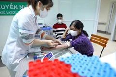 Nhân viên y tế lấy mẫu máu xét nghiệm cho bệnh nhân. (Ảnh: Minh Quyết/TTXVN)