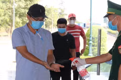 Người dân phải đeo khẩu trang, đo nhiệt độ và sát khuẩn tay để phòng dịch. (Ảnh: Sỹ Tuyên/TTXVN) 
