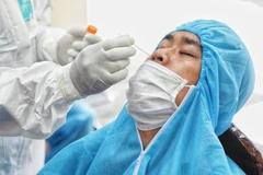 Nhân viên y tế lấy mẫu xét nghiệm COVID-19 cho người dân. (Ảnh: Thành Đạt/TTXVN)