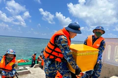 Các chiến sỹ vận chuyển những món quà từ các cơ quan đơn vị và Kiều bào lên đảo. (Ảnh: Thùy Giang/Vietnam+)