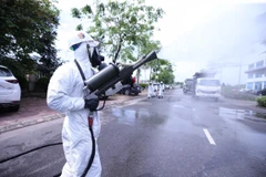 Bộ đội hóa học phun thuốc khử trùng Bệnh viện Bệnh Nhiệt đới Trung ương cơ sở Đông Anh. (Ảnh: Minh Đức/TTXVN)