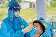 Nhân viên y tế lấy mẫu cho người dân. (Ảnh: TTXVN/Vietnam+)