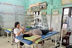 Nhân viên y tế chăm sóc sức khỏe cho người dân tại một trạm y tế ở tuyến xã. (Ảnh: Nguyên Linh/TTXVN)