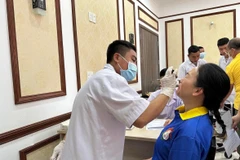 Nhân viên y tế xét nghiệm COVID-19 cho người dân. (Ảnh: Thùy Giang/Vietnam+)