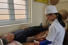 Nhân viên y tế khám bệnh cho người dân tại một trạm y tế. (Ảnh: T.G/Vietnam+)