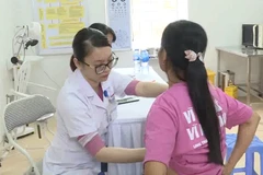 Bác sỹ thực hiện khám sàng lọc phát hiện sớm ung thư vú cho người dân. (Ảnh: PV/Vietnam+)