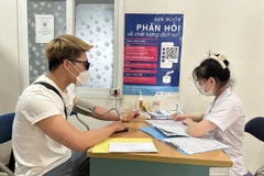 Nhân viên y tế khám, kiểm tra sức khỏe cho trường hợp điều trị bệnh HIV. (Ảnh: PV/Vietnam+)