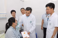 Thứ trưởng Bộ Y tế Trần Văn Thuấn đã thăm hỏi, tặng quà động viên nạn nhân trong vụ cháy ở Trung Kính. (Ảnh: PV/Vietnam+)