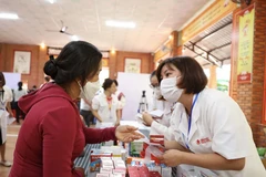 Tư vấn, cấp thuốc cho người dân. (Ảnh: Tuấn Anh/TTXVN)