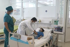Bác sỹ Bệnh viện Đa khoa tỉnh Vĩnh Long thăm khám cho bệnh nhi bị sốc do sốt xuất huyết trong tình trạng nặng. (Ảnh: Lê Thúy Hằng/TTXVN)