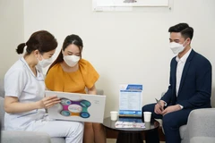 Nhân viên y tế tư vấn chăm sóc sức khỏe cho người dân tại bệnh viện. (Ảnh: PV/Vietnam+)