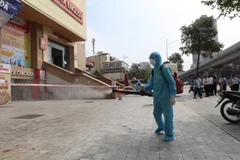 Lực lượng y tế phun khử khuẩn nơi ở một trường hợp F0. (Ảnh: Thành Đạt/TTXVN)