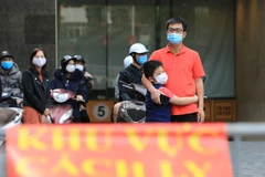 Các cư dân sinh sống tại chung cư Sky City Tower chờ đến giờ dỡ bỏ cách ly. (Ảnh: Thành Đạt/TTXVN)