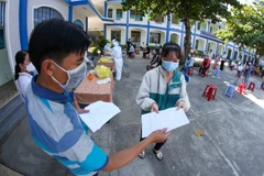 Phát tờ khai thông tin y tế cho người dân Phú Yên đến lấy mẫu xét nghiệm COVID-19. (Ảnh: Trần Lê Lâm/TTXVN)