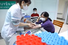 Nhân viên y tế lấy mẫu xét nghiệm cho người bệnh. (Ảnh: Minh Quyết/TTXVN)