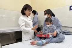 Tiến sỹ Phạm Minh Châu thăm khám cho bệnh nhi bị ung thư mắt đang điều trị tại Bệnh viện Mắt Trung ương. (Ảnh: T.G/Vietnam+)