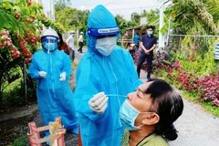 Nhân viên tại y tế cơ sở lấy mẫu xét nghiệm cho người dân. (Ảnh: PV/Vietnam+)