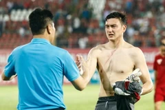 Văn Lâm nhận lời động viên từ huấn luyện viên thủ môn Nguyễn Đức Cảnh sau màn trình diễn ấn tượng. (Ảnh: Minh Chiến/Vietnam+)