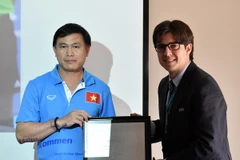 Trưởng đoàn Trần Anh Tú (trái) thay mặt tuyển Futsal Việt Nam nhận danh vị chứng nhận tham dự Futsal World Cup của FIFA. (Ảnh: VFF)