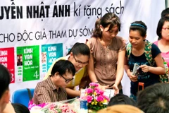 Nhà văn Nguyễn Nhật Ánh ký tặng độc giả tại Hà Nội. Có rất nhiều gia đình có bố mẹ và các con cùng là fan của bộ truyện. (Ảnh: Kim Đồng)